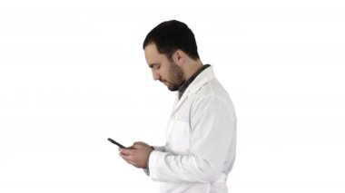 Yürüyen doktor ya da hemşire beyaz arka planda cep telefonuyla mesaj atıyor..