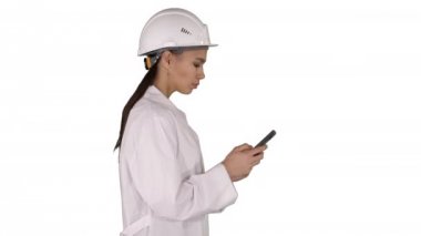 Beyaz arka plan üzerinde yürürken cep telefonu mesaj kullanarak mühendisi.