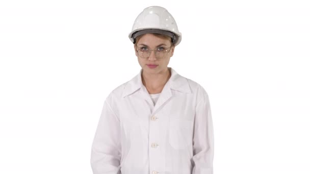 Νεαρή γυναίκα μηχανικός στο σκληρό καπέλο περπάτημα σε λευκό φόντο. — Αρχείο Βίντεο