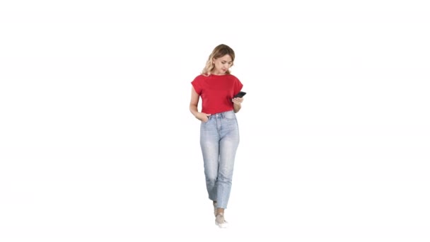 Blonde woman texting with her smart phone walking on white background. — Stock Video