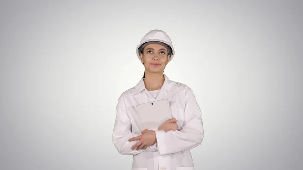 Female doctor engineer walking with digital tablet on gradient background. — Stock Photo, Image