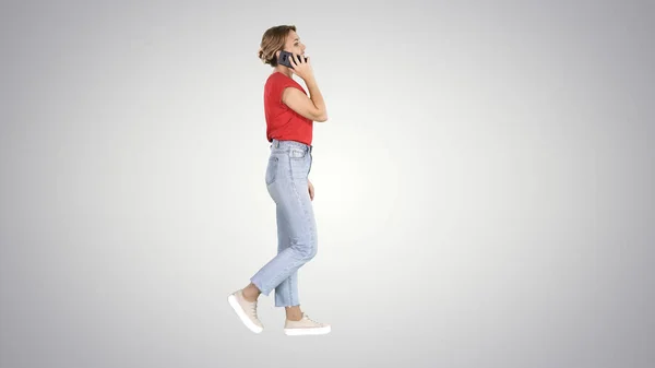 Menina bonita ter um telefonema andando no fundo gradiente. — Fotografia de Stock