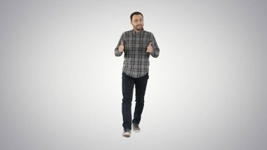 Tam boy portre. Yürüyen adam gradyan arka planda bir şeyi işaret edip açıklıyor. 4K çözünürlükte profesyonel atış. 004. Kullanabilirsin, mesela. Ticari videonuzda, iş