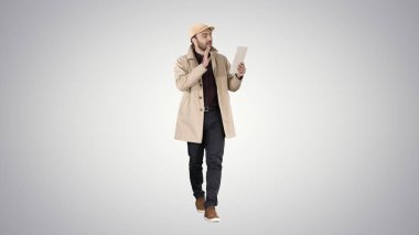 Yakışıklı delikanlı yapma video tablet ile ara üzerinde gradyan arka planı.