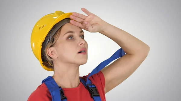 Engineer construction worker woman fascinated by the scale of construction on gradient background. — Stock Photo, Image