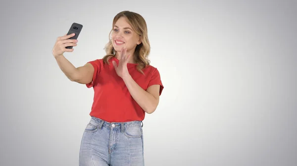 Menina bonito fazendo selfie andando no fundo gradiente. — Fotografia de Stock