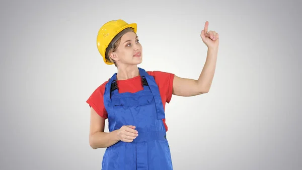 Jonge lachende werknemer woman wijzend op imaginaire knopen op imaginaire scherm op de achtergrond met kleurovergang. — Stockfoto