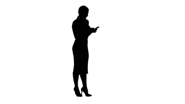 Mooie zakenvrouw silhouet met behulp van mobiele telefoon SMS iets. — Stockfoto