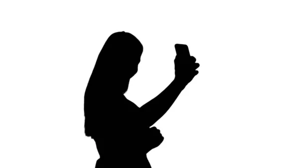Silhouette Schöne junge Frau macht Selfies. — Stockfoto