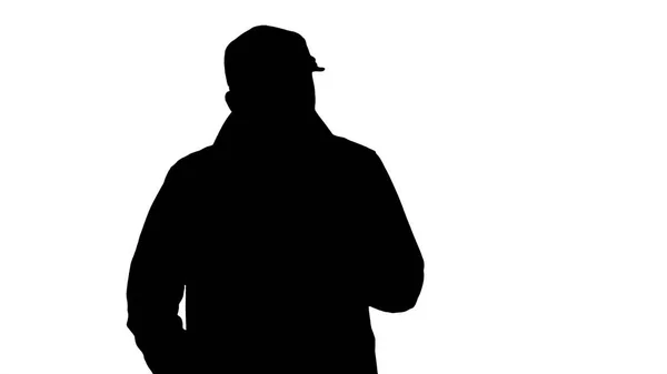 Silhouette ein positiver bärtiger Mann im Trenchcoat, der spazieren geht und spricht. — Stockfoto