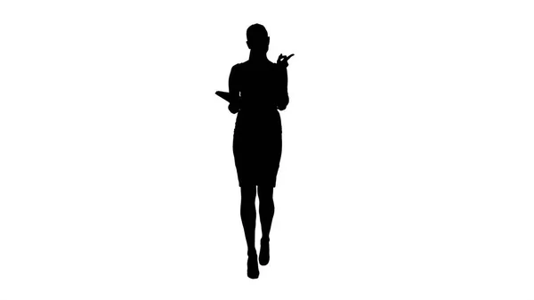 Silhouette junge Geschäftsfrau geht und liest aus Notizbuch. — Stockfoto