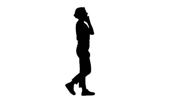 Silueta Hermosa chica joven que tiene una llamada telefónica caminando. — Foto de Stock
