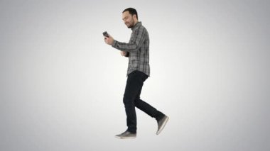 Eğlence, teknoloji, iletişim ve insan kavramı - kullanarak ve degrade arka plan üzerinde yürürken Smartphone'da arıyor genç adam.