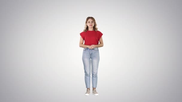 Young beautiful cute cheerful woman standing and looking at camera waiting for something on gradient background. — Stock Video