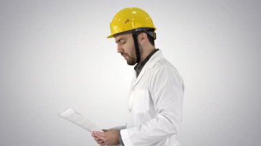 Kağıtları ile yürüyüş ve civarı degrade arka plan üzerinde kontrol yüklenici mühendis.