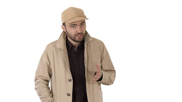 Un mâle barbu positif vêtu d'un trench coat marchant et parlant sur fond blanc . — Photo