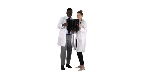 严重善良的女医生和非洲裔美国医生研究大脑 x 射线在白色背景. — 图库照片