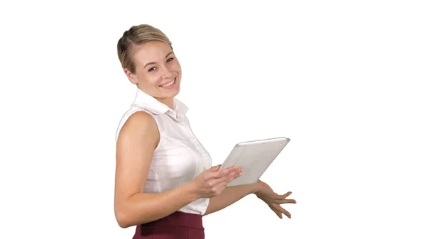 Female office clerk walking with tablet and smiling broadly when talking to camera on white background. — Stock Photo, Image