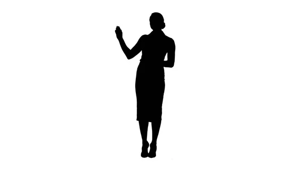 Silhouette Encantadora mujer enérgica sonriente en ropa formal hablando con la cámara y señalando a los lados . —  Fotos de Stock