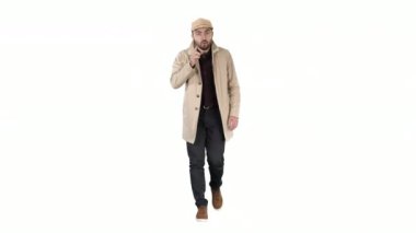 Hafif trençkotlu yakışıklı adam kamerayla konuşuyor. Odaklan ve düşün. Beyaz arka planda hareketler yapıyor..