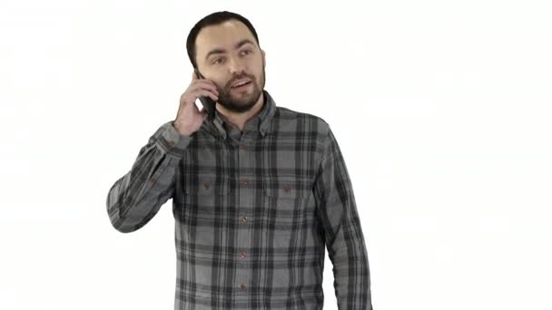 Um homem está falando ao telefone e sorrindo no fundo branco. — Vídeo de Stock