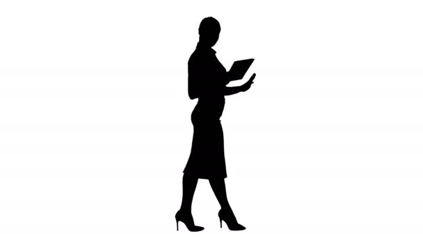 Silhouette Woman walking using digital tablet and talking to camera. — Stock Video