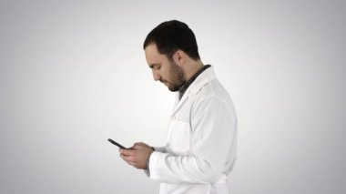Doktor veya hemşire manifatura degrade arka plan üzerinde bir cep telefonuyla yürüyüş.
