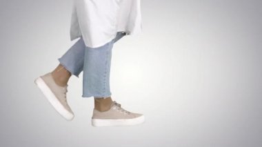 Kadın doktor bacakları eğimli arka planda yürüyor.