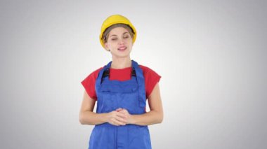 Degrade arka plan üzerinde hayali ekranda sanal butonlar işaret eden genç gülümseyen çalışan kadın.