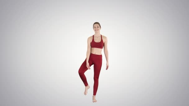 Junge Yogi-Frau praktiziert Yoga-Konzept, Variation von utthita hasta padangushthasana Pose, trivikramasana, stehende Spaltungen auf Steigungshintergrund. — Stockvideo