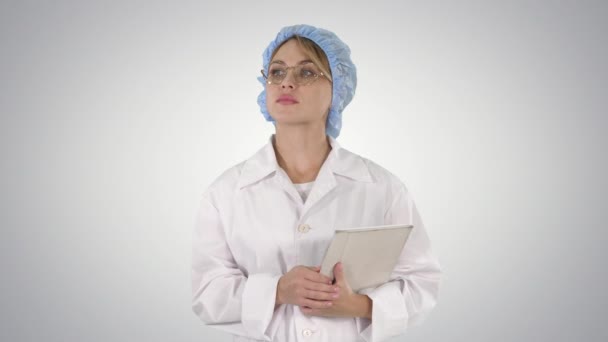 Vrouwelijke arts die tablet vasthoudt en op een hellende achtergrond loopt. — Stockvideo