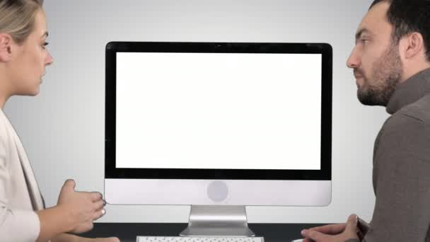 Geschäftskollegen, ein Mann und eine Frau unterhalten sich über das, was auf dem Bildschirm des Computers auf dem Hintergrund des Gefälles zu sehen ist. — Stockvideo