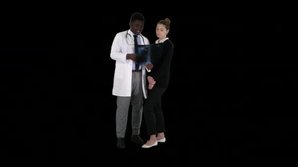 Доктор показывает пациенту рентген грудной клетки, канал Альфа — стоковое видео
