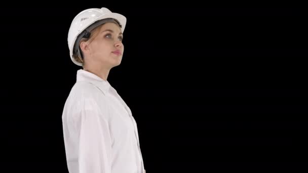 Νεαρή γυναίκα με σκληρό καπέλο να περπατάει και να κοιτάζει τριγύρω, κανάλι Άλφα — Αρχείο Βίντεο