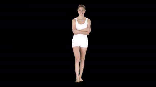 Jonge vrouw loopt in witte sportkleding blootsvoets en glimlachend breed, Alpha Channel — Stockvideo