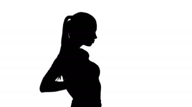 Siluet Güzel esmer kız Elleri kalçasında yürüyor.