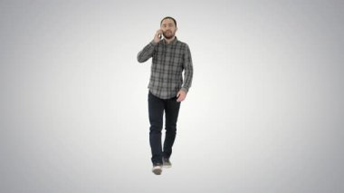 Genç adam arka planda cep telefonuyla konuşuyor..