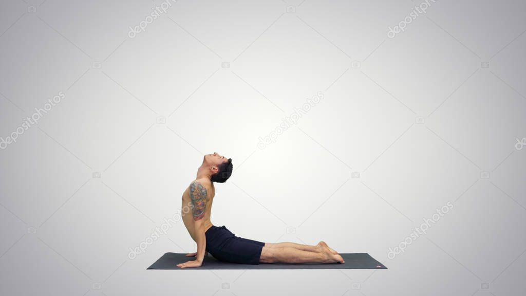 Flexible strong yoga man in Upward and Downward Facing Dog Urdhva Mukha Svanasana on gradient background.