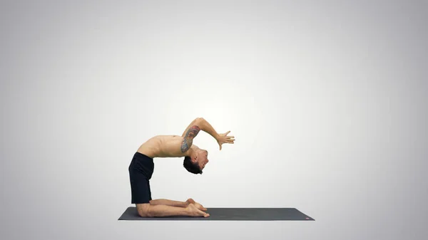 Yogi robi pozy jogi wielbłąda na gradientowym tle. — Zdjęcie stockowe