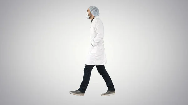 Walking läkare puting medicinsk mask på på lutning bakgrund. — Stockfoto