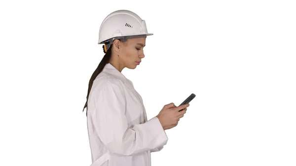 Engineer using mobile phone texting while walking on white background. — Stock Photo, Image