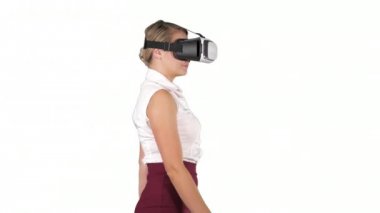 Beyaz arka planda yürüyen VR kulaklıklı kadın..