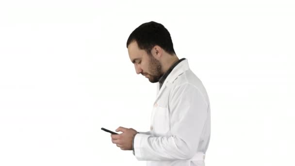 Homem médico andando e olhando atentamente para a tela do celular Fazendo sintonia cantar no final no fundo branco . — Vídeo de Stock
