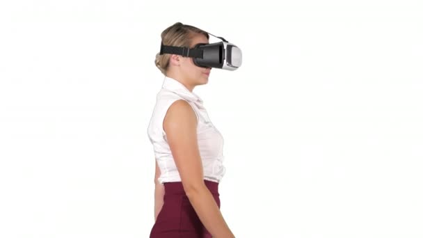 Vrouw in VR-headset loopt op witte achtergrond. — Stockvideo