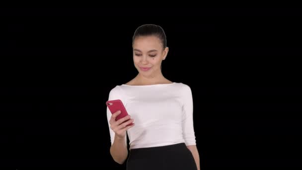 Schöne junge Frau mit einem Handy SMS, Alpha Channel — Stockvideo