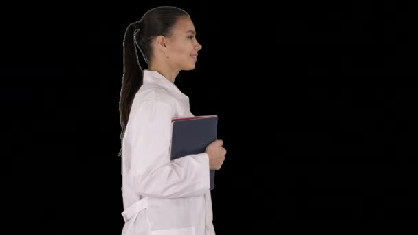 Счастливая улыбающаяся женщина-доктор ходит с блокнотами или документами, Альфа канал — стоковое видео
