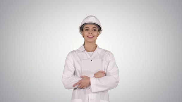 Ingeniera médica mujer caminando con tableta digital sobre fondo de gradiente . — Vídeo de stock