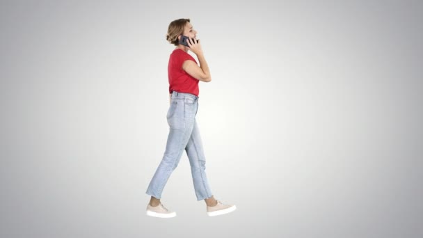 Mooi jong meisje met een telefoontje lopen op gradiënt achtergrond. — Stockvideo