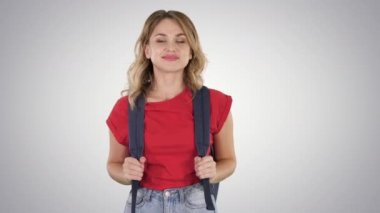 Sırt çantası ve degrade arka plan üzerinde yürüme kot ile rahat T-shirt genç güzel kadın.