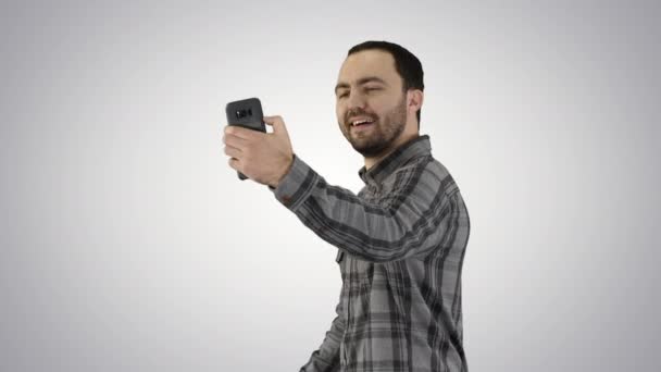 Adolescente chico haciendo un selfie al caminar sobre gradiente fondo. — Vídeos de Stock